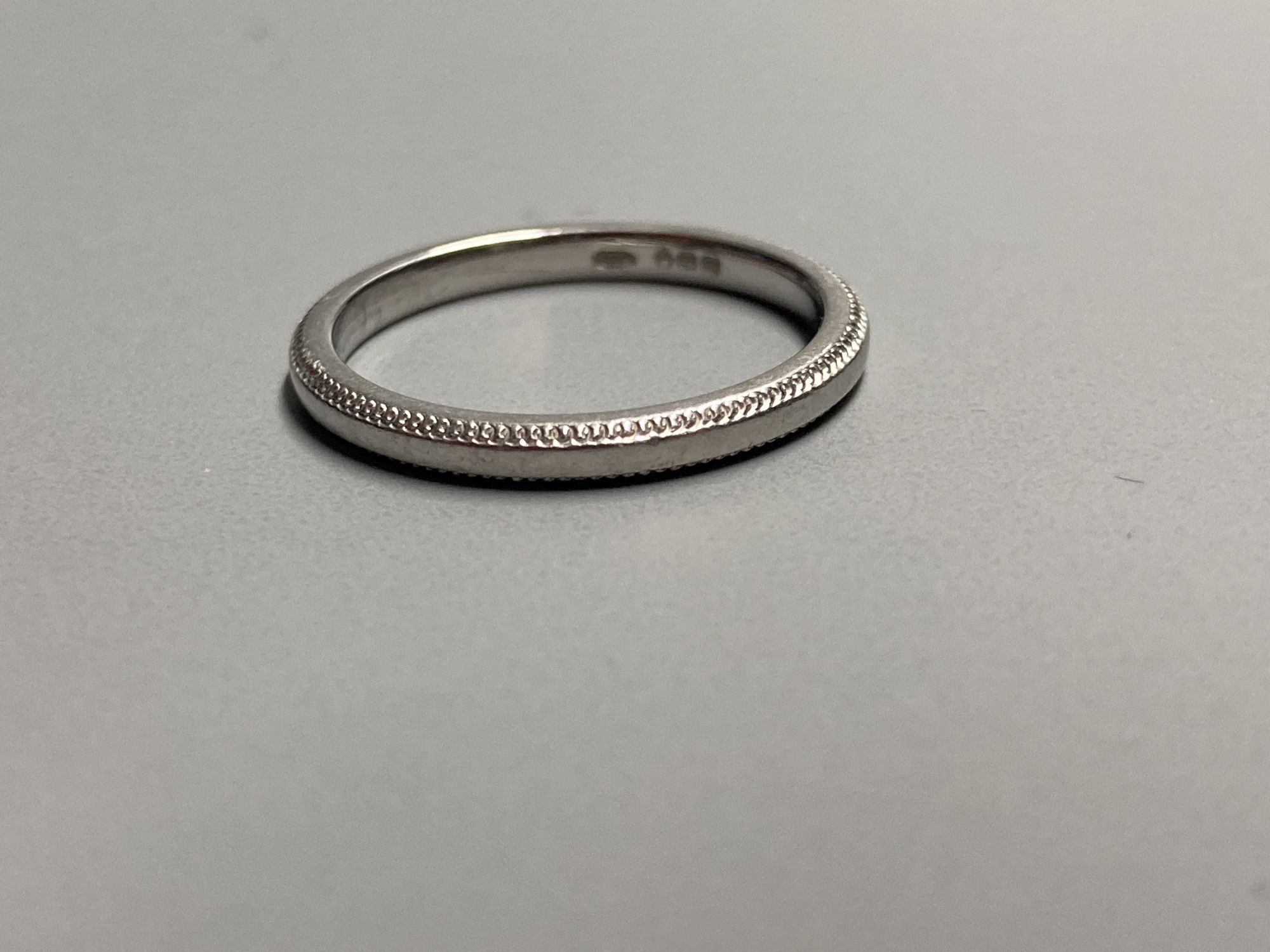 A modern platinum wedding band with milled edges, size L, 3.2 grams.